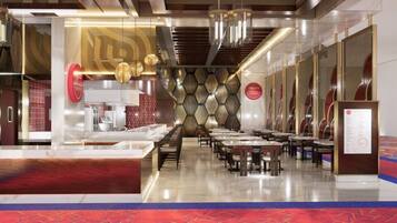 A modern restaurant with a long counter, multiple tables, and a patterned wall design.