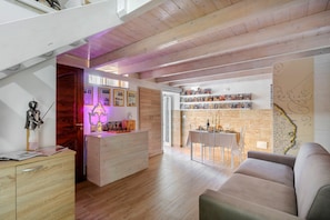 Un interior moderno con techo de madera, zona de comedor con mesa y sillas, y un sofá.
