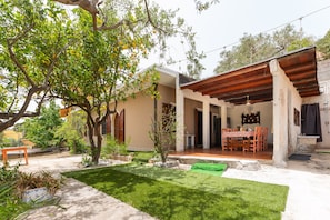 A house with a covered patio, a lawn, and a dining area.