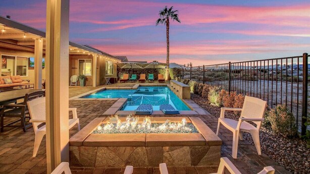 A pool area with lounge chairs, a fire feature, and a view of the landscape. - Secluded Private Golf/Pool Home With Game Room (Indio)