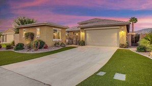 A two-story house with a garage, a driveway, and well-maintained landscaping. - Secluded Private Golf/Pool Home With Game Room (Indio)