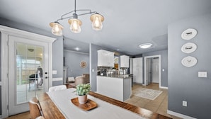 Una cocina moderna con armarios blancos, una isla central e iluminación colgante.