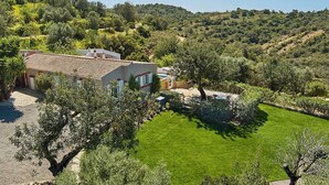 A house with a tiled roof, surrounded by a well-maintained lawn and trees. - Lovingly Restored Country Villa, A/C, Private Pool (Fenced), Idyllic Views - 15mins drive to Tavira (Santa Catarina da Fonte do Bispo)