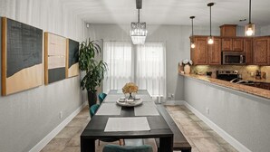 Una cocina moderna con armarios de madera, microondas integrado e iluminación colgante.
