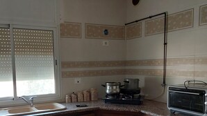Una cocina con armarios de madera, encimera de granito, un fregadero, una estufa y un tostador.