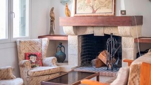 A cozy living room with a fireplace, a sofa, a coffee table, and decorative items. - R153 Villa con Piscina en Coma-ruga (Coma-ruga)