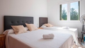 A hotel room with two beds, a large window, and a fan. - R153 Villa con Piscina en Coma-ruga (Coma-ruga)