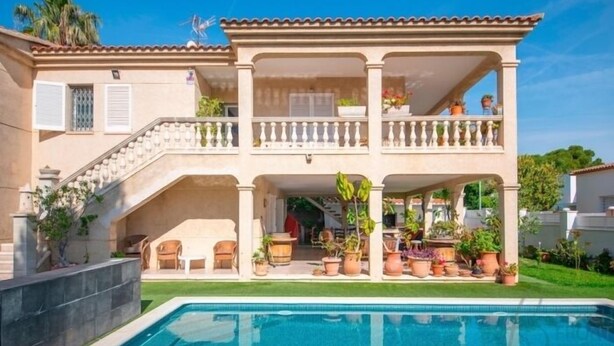 A two-story house with a pool, outdoor seating, and potted plants. - R153 Villa con Piscina en Coma-ruga (Coma-ruga)