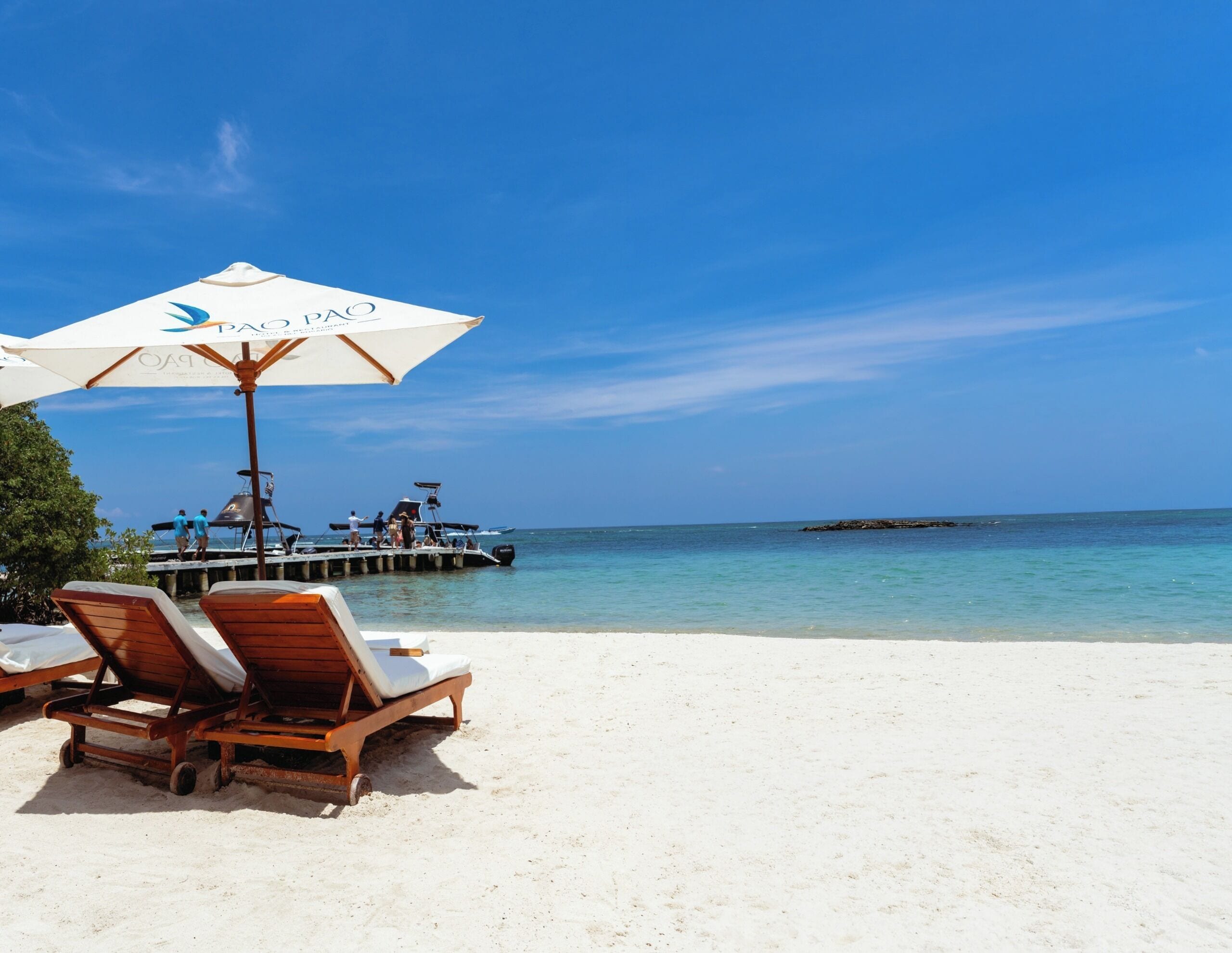 Aan het strand, wit zand, gratis strandcabana's