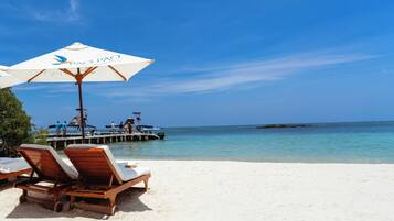 Aan het strand, wit zand, gratis strandcabana's