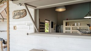 A rustic kitchen with a wooden counter, a hanging light fixture, and a refrigerator. - Complete relaxation at Villa Lakaz with its spacious terrace and private pool. (Le Moule)