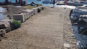 A rocky waterfront with boats docked and people relaxing by the water. - 1 Bedroom Private vacation home in La Seyne-sur-Mer (La Seyne-sur-Mer)