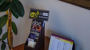 A reception desk with a WiFi sign, a calendar, and a mirror reflecting a room with a lamp and pillows. - LaCasaDeiNonni - Lakes&Relax (Varano Borghi)