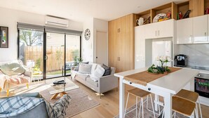 A modern kitchen with white cabinets, a wooden countertop, and a refrigerator. - Stunning, modern, two-story detached townhouse (Footscray)