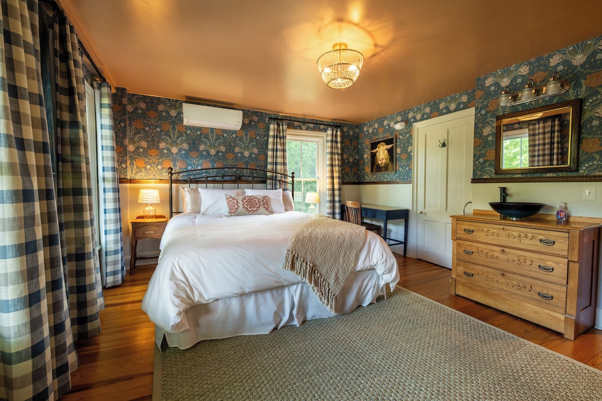 A bedroom with a bed, dresser, and a mirror.