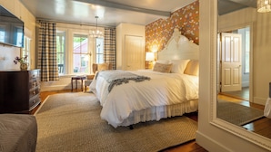 A bedroom with a large bed, a dresser, a chair, and a mirror. - Wilder House Berkshires (Sheffield)