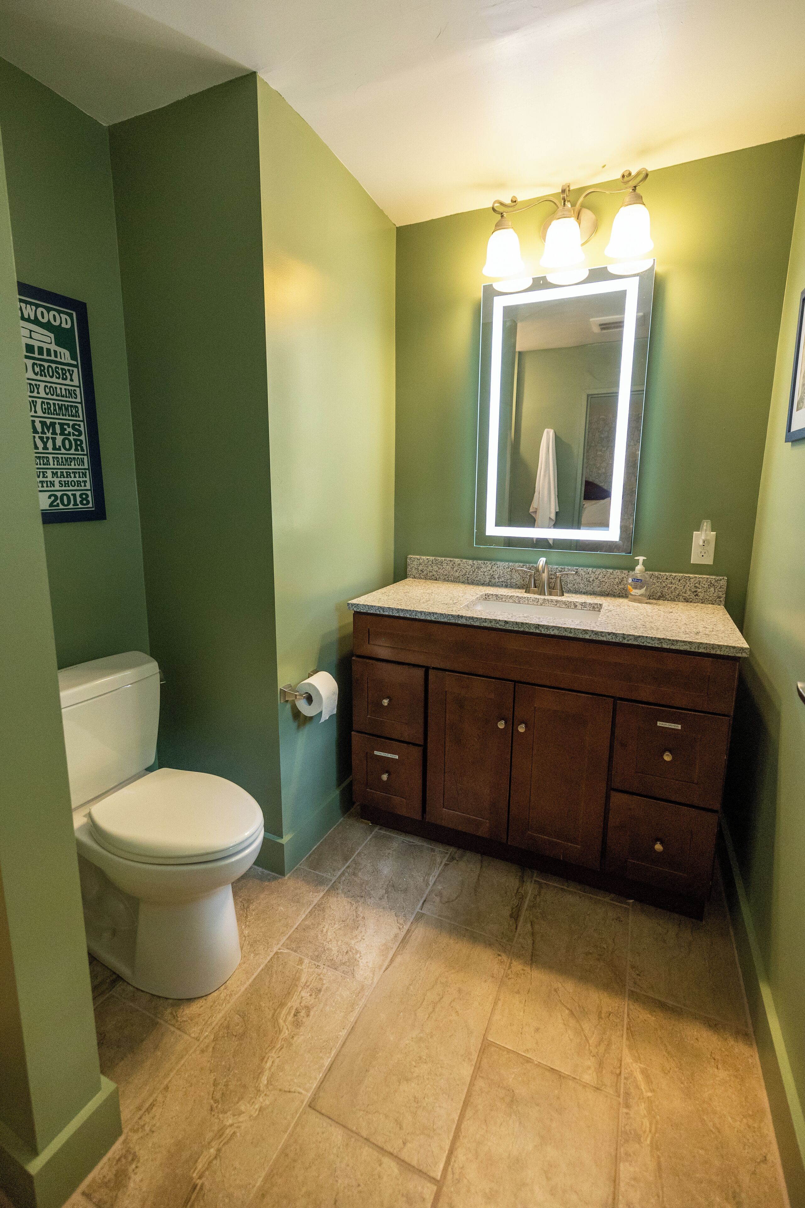 Un baño con inodoro, lavamanos y tocador.