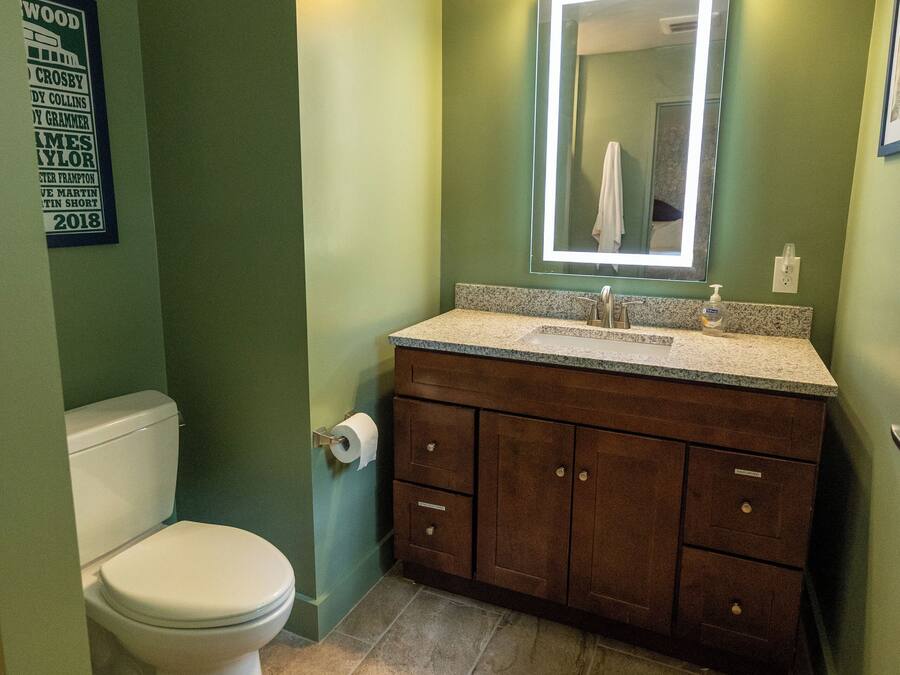 Un baño con inodoro, lavamanos y tocador.