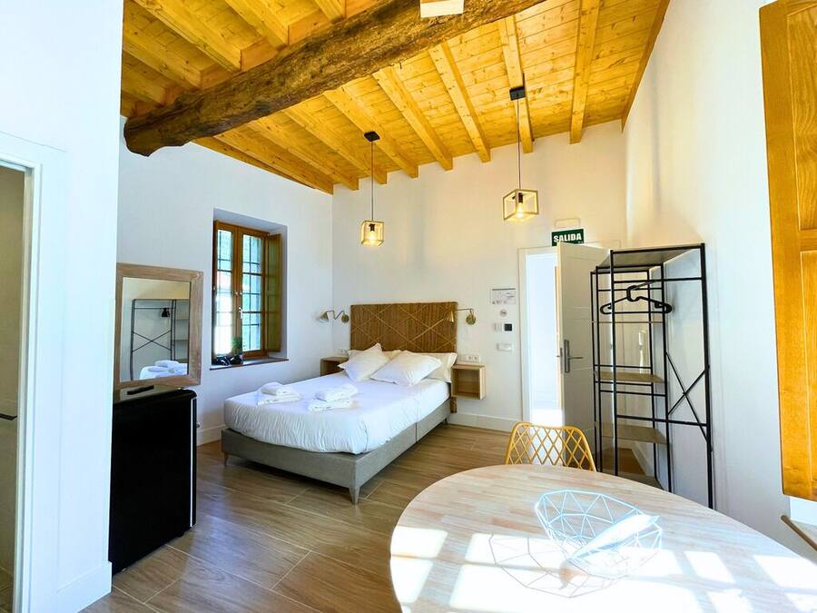 Ein Schlafzimmer mit Bett, Nachttisch, Lampe und Kleiderschrank.