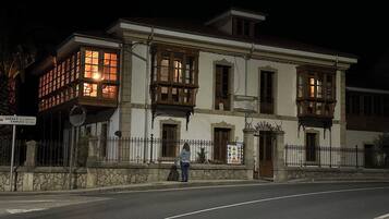 Ein historisches Gebäude mit zahlreichen Fenstern und einem Balkon, mit einem Schild, das es als Hotel kennzeichnet.
