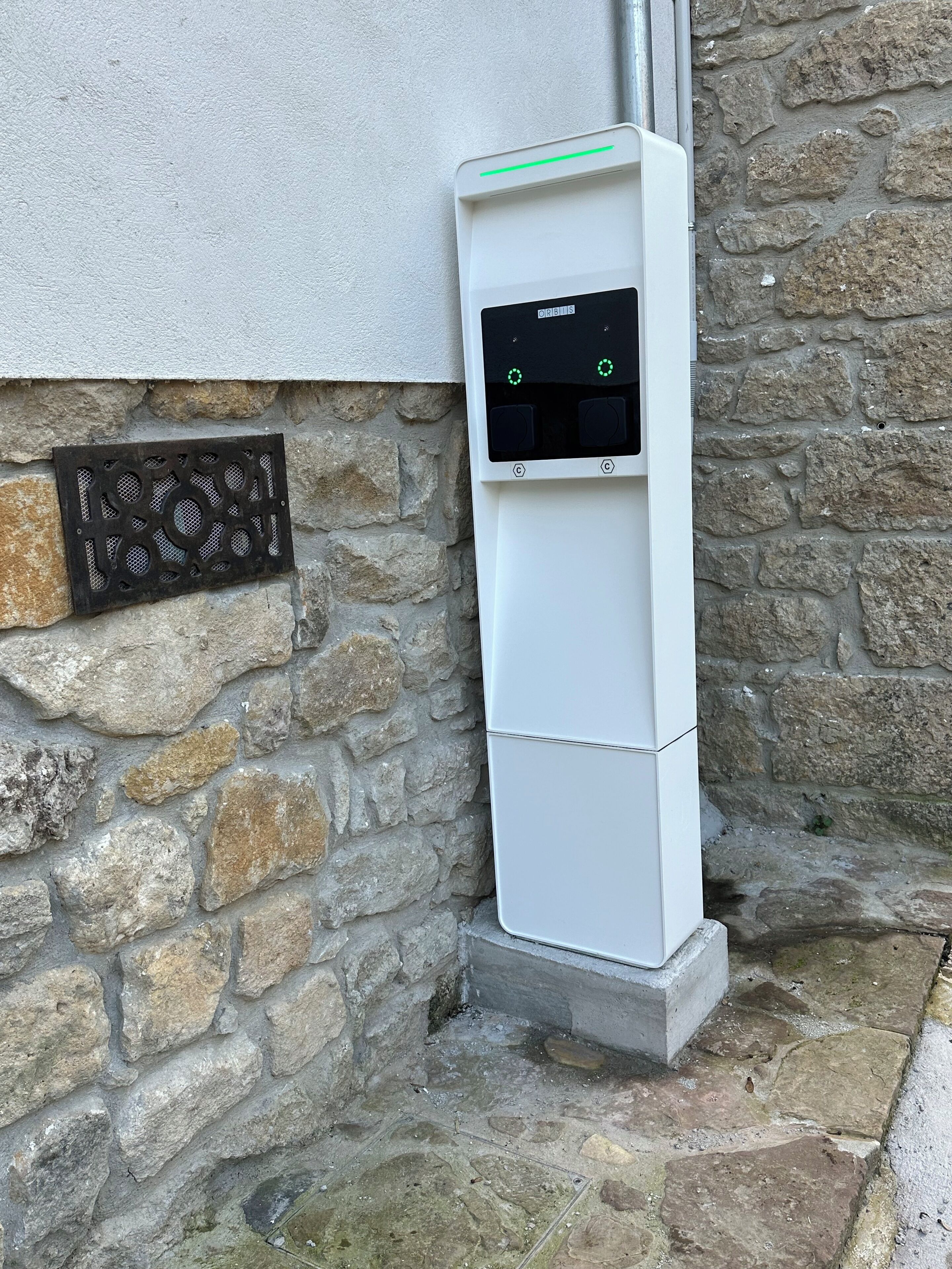 Caja de medidores de servicios instalada en una pared de piedra, junto a un cuadro eléctrico blanco.