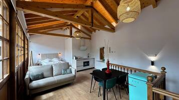 Um quarto amplo com cama beliche, área de refeições e cozinha.