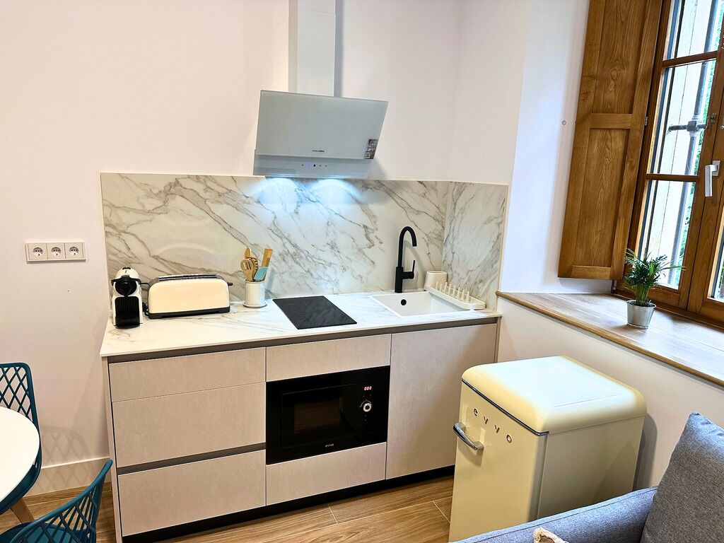 A compact kitchen with a built-in oven, a microwave, and a sink.