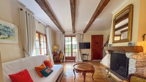Una sala de estar acogedora con un sofá blanco, una chimenea y un televisor.