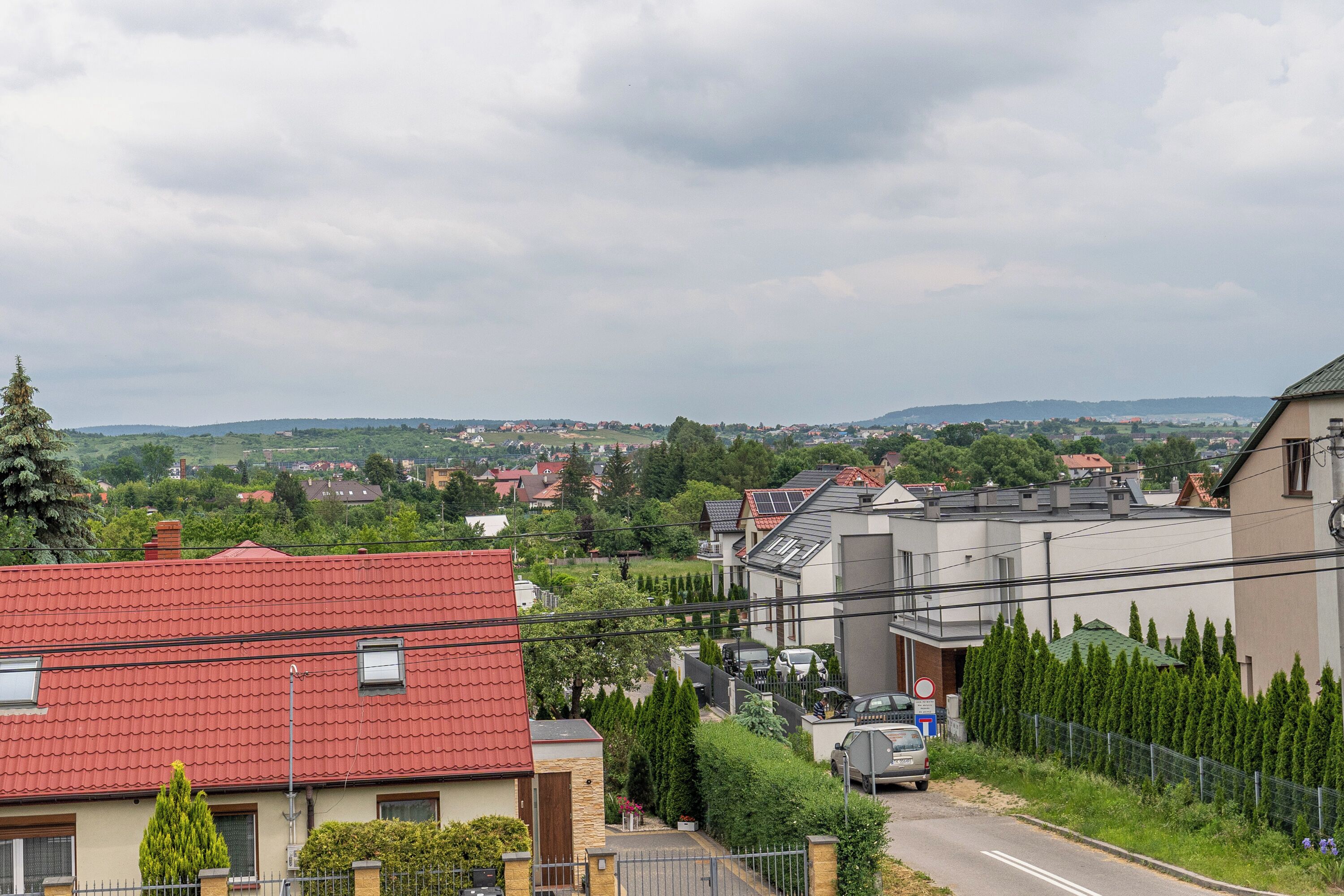 Ein Wohngebiet mit Häusern, einer Straße und einer entfernten Stadtansicht.