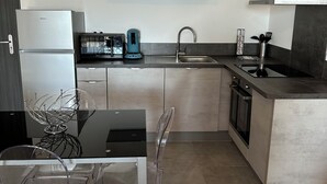 Moderni keittiö, jossa on sisäänrakennettu uuni, mikroaaltouuni, leivänpaahdin ja pesuallas.