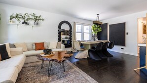 Un salon moderne avec un canapé, une table basse et un coin repas avec des chaises.