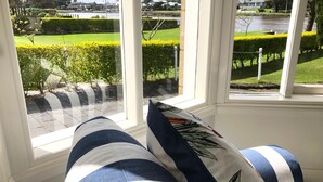 A room with a view of a landscaped garden through large windows. - Douglas Riverside (Port Fairy)