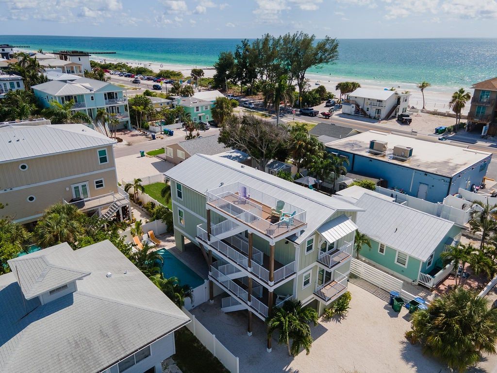 Un quartier résidentiel situé sur la côte, avec des immeubles à plusieurs étages, une plage et une vue dégagée sur l’océan.