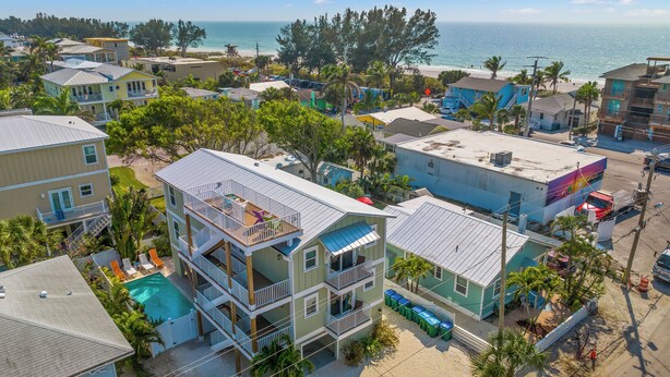 A multi-story building with a pool, balconies, and a view of the ocean. - Family Tides A – AMI Retreat w/ Pool, Rooftop Deck & Gulf/Bay Views Steps To Beach (Bradenton Beach)