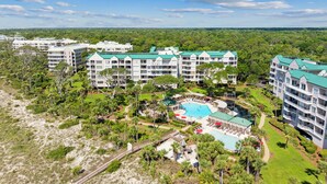 A resort with multiple buildings, a central pool area, and surrounding greenery. - 3402 Windsor @ Palmetto Dunes | Oceanfront | Steps to Beach | Pool | Stunning Views (Hilton Head Island)