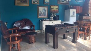 A cozy room with a foosball table, wooden chairs, and a cabinet. - Recanto das Orquideas (Quatis)