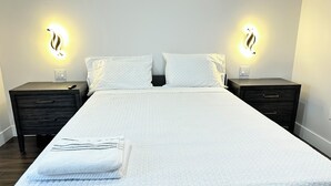 A neatly made bed with white bedding and two bedside tables with lamps. - GETAWAY/PRIVATE SUITE C, (Lutz)