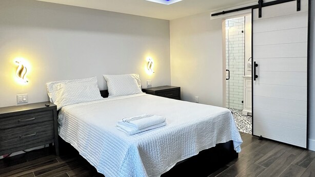 A modern bedroom with a bed, bedside tables, and a wardrobe. - GETAWAY/PRIVATE SUITE C, (Lutz)
