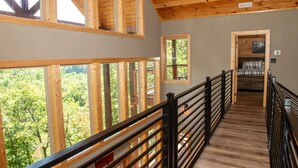 A wooden interior with a view of greenery outside. - 3410 sq ft Very Large-Pool Community cabin, Mountain Views-4 King beds-POOL tble (Pigeon Forge)