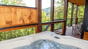 A hot tub on a wooden deck with a view of trees and hills. - 3410 sq ft Very Large-Pool Community cabin, Mountain Views-4 King beds-POOL tble (Pigeon Forge)