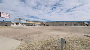 Een motel met een bord waarop 'Travelers Lodge' staat en een bord van U-Haul.
