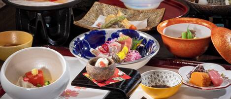Un assortiment de plats présentés sur un plateau, notamment des sushis et d’autres spécialités de la cuisine asiatique.