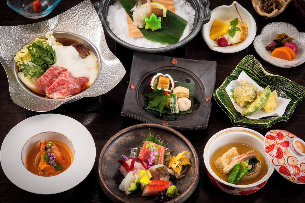 A variety of dishes on a table, including sushi, sashimi, and other Japanese cuisine.