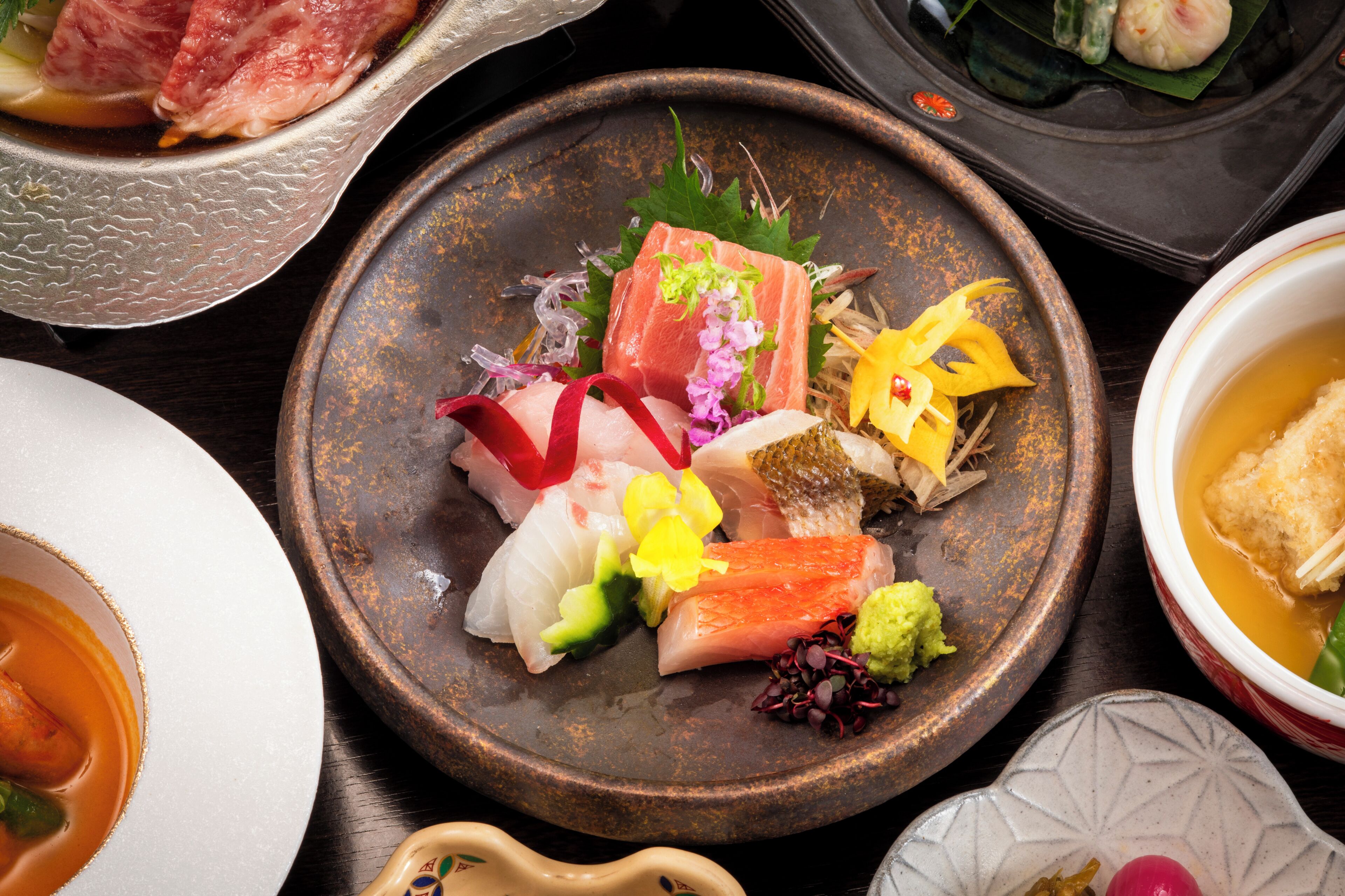 A variety of dishes on a table, including sushi and other Asian cuisine.