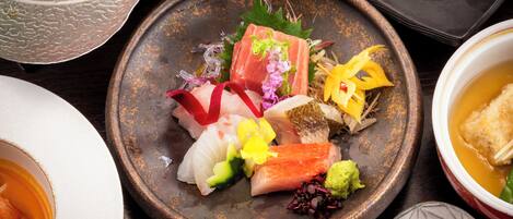 A variety of dishes on a table, including sushi and other Asian cuisine.