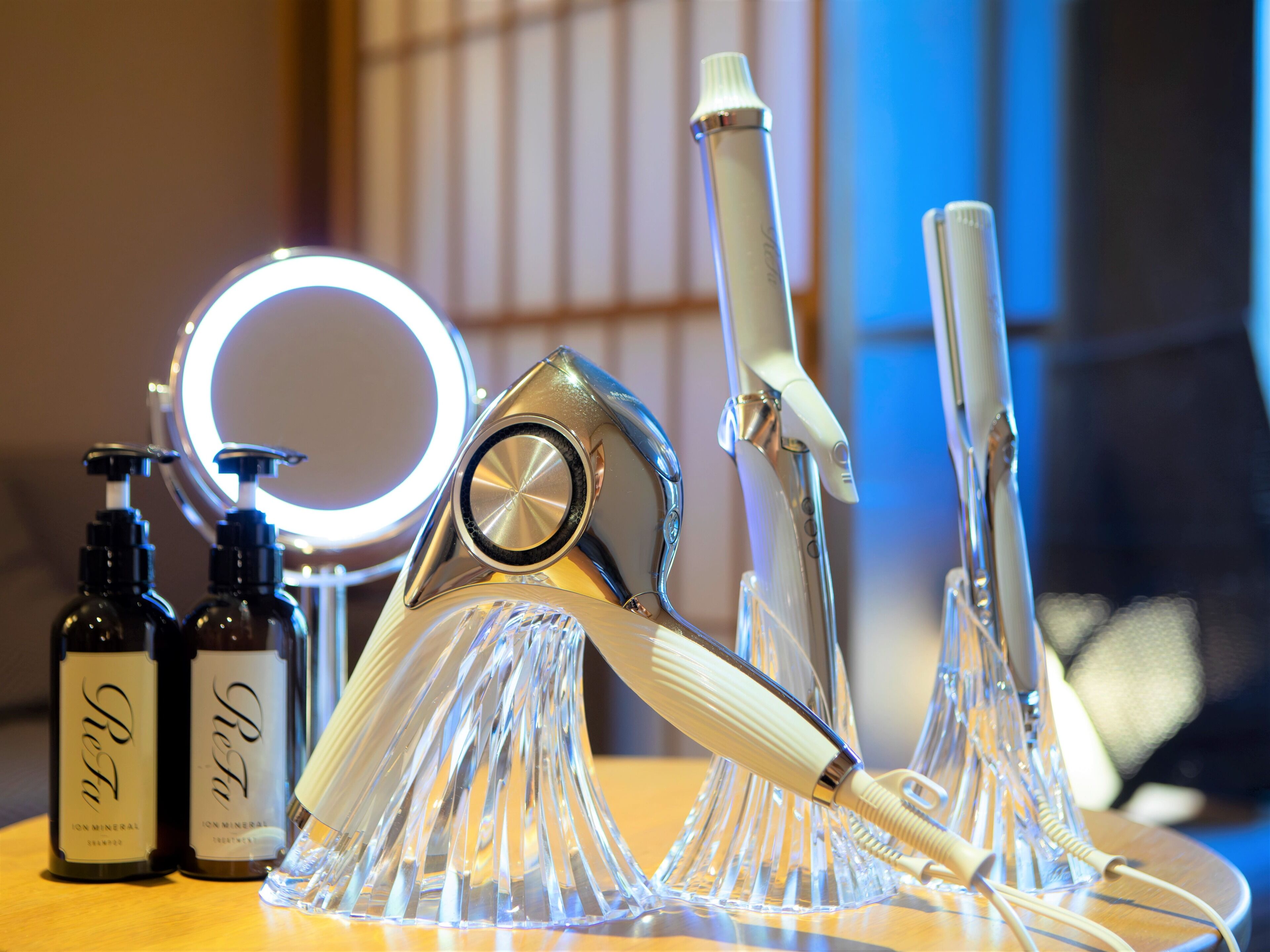 A bathroom vanity with a mirror, two bottles of shampoo, and a hairdryer.