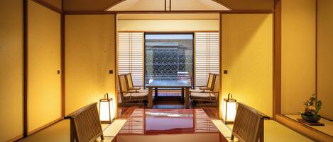 A traditional Japanese room with tatami flooring, a low table, and shoji screens.