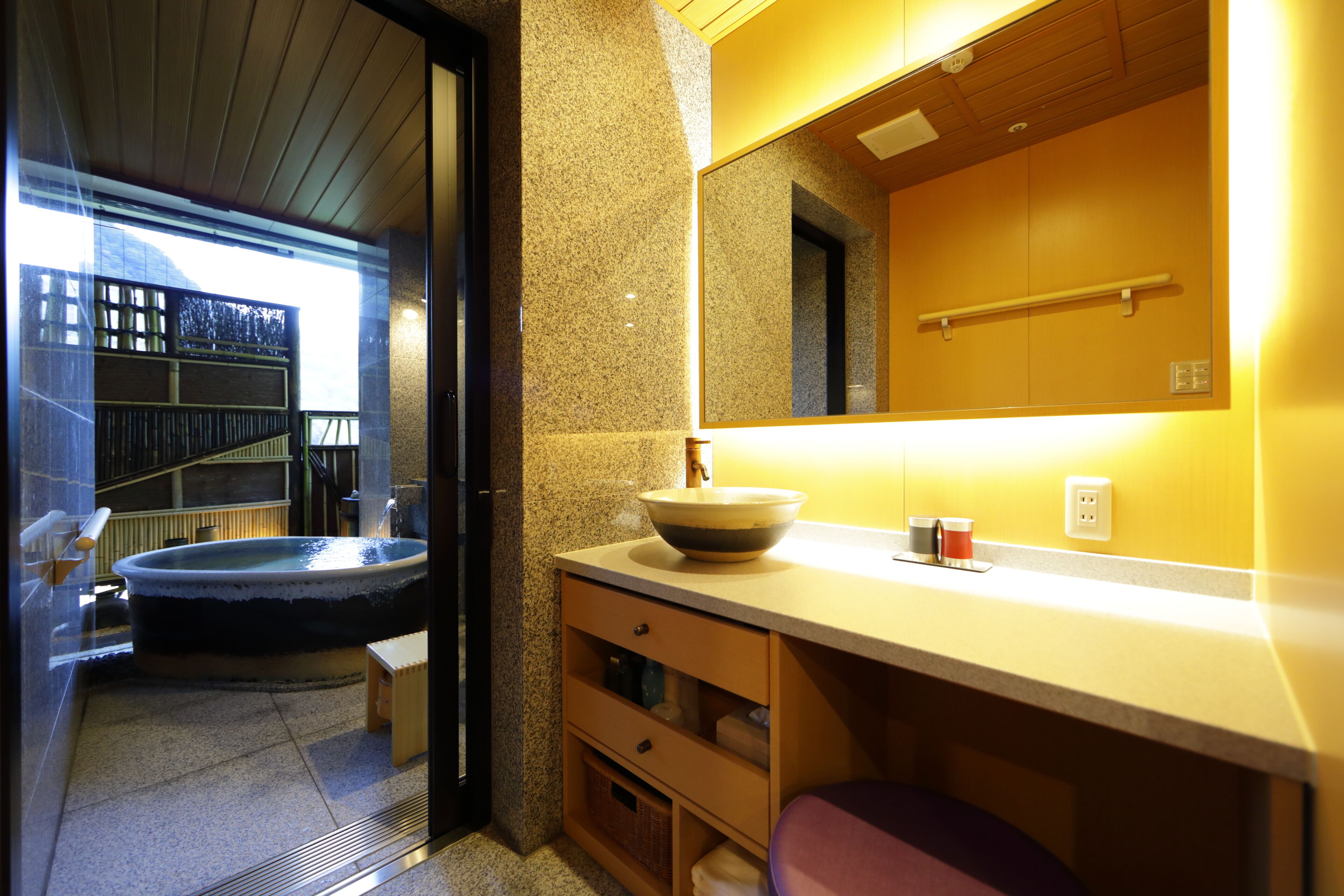 A modern bathroom with a freestanding bathtub, a large mirror, and a wooden vanity.