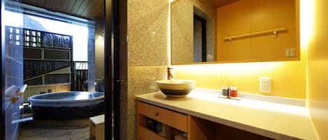 A modern bathroom with a freestanding bathtub, a large mirror, and a wooden vanity.