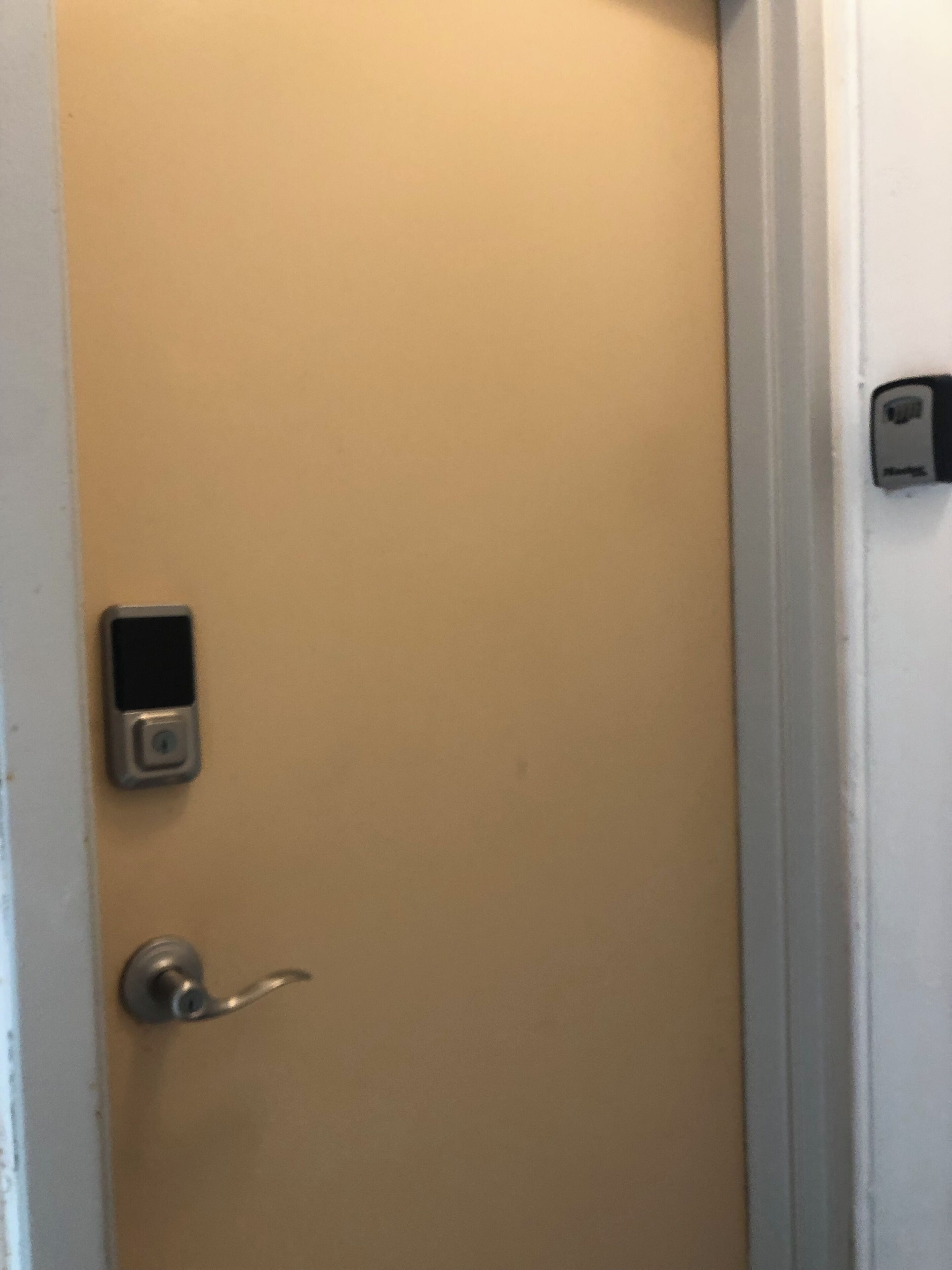 Una puerta con cerradura digital y una cerradura tradicional.